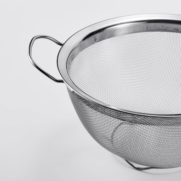 Stainless steel colander with strong handles and fine mesh for effective straining.
