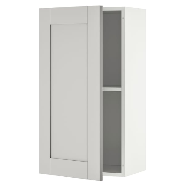 This is a KNOXHULT kitchen wall cabinet in white with one open door showing the gray interior shelf.