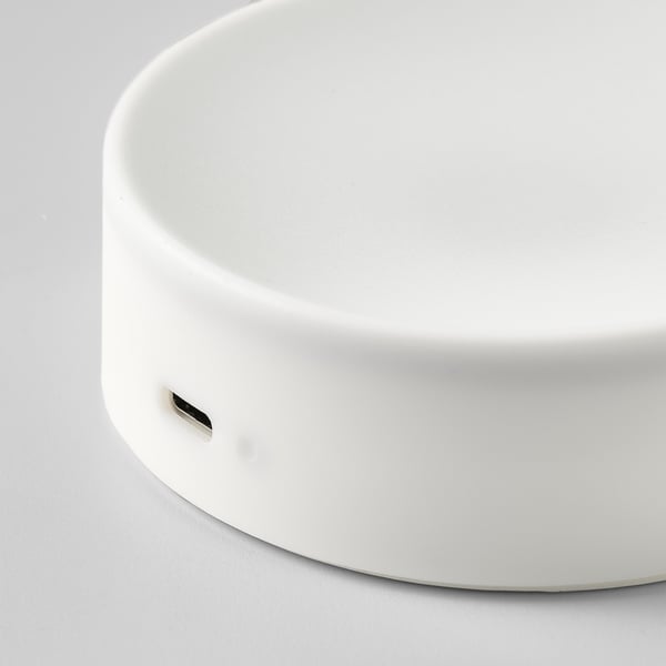 Round, white, modern lamp with smooth surface and usb-c charging port.