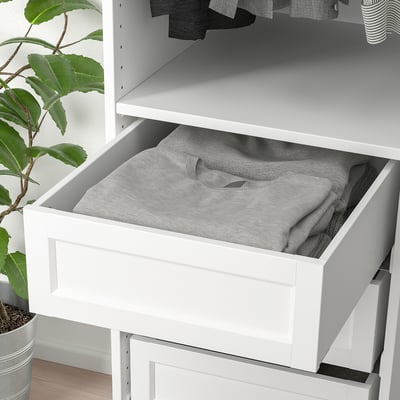 A white drawer with gray fabric inside, part of an organizational system. Its designed for easy storage and access to items like clothes.