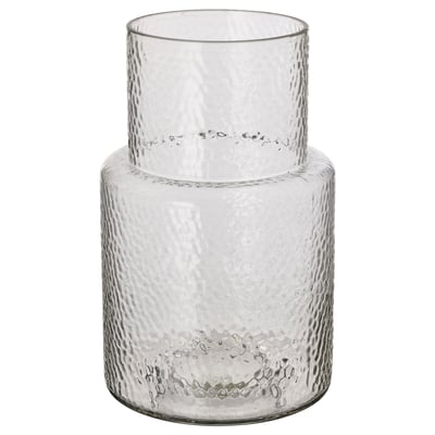 A KONSTFULL vase, clear with textured glass, designed by ilse crawford. It has a tall, cylindrical shape with a narrower neck, ideal for flowers.