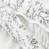 White duvet cover with floral print and zipper closure, featuring soft cotton and viscose blend for temperature regulation and comfort.