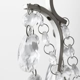 Chandelier detail: clear glass prisms hang from metallic loops, reflecting light.