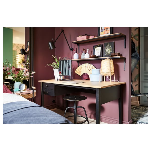 Cozy home office with KULLABERG stool, shelves, and decor. Bright lamp, pink walls, wooden desk.