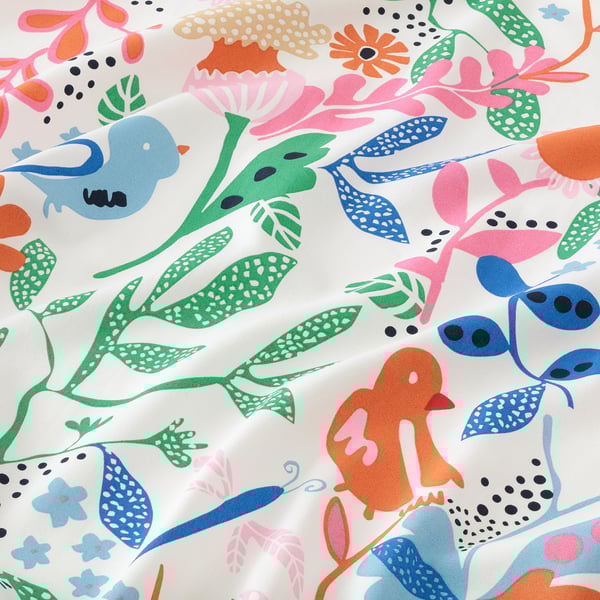 Vibrant pre-cut fabric playful birds, flowers, & leaves on white, perfect for crafting & sewing projects.