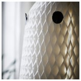 Ghostly lantern with patterned design, illuminated warmly. Textured, diamond-shaped cutouts cast intricate shadows.