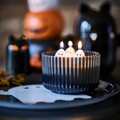 Three lit ghost candles in ribbed glass, adding spooky & cute halloween ambiance with jelly scent.