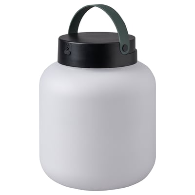 Depicts a LÄNSPORT portable lamp in white. It a sleek, round shape with a black lid and green handle, designed for both indoor and outdoor use.