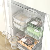 Open fridge with adjustable shelves and transparent drawers, showing organized food and drink items.