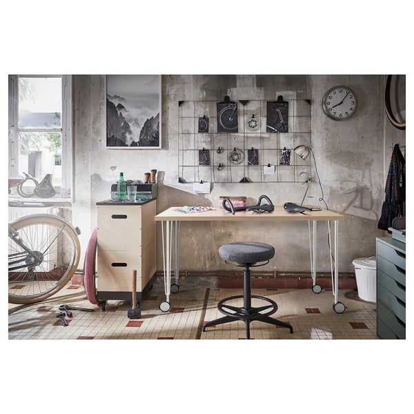 Industrial home office with LAGKAPTEN desk, bike accessories, and wall art.