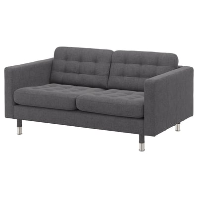 Modern dark grey fabric loveseat with tufted back and seat, chrome legs, and minimalist design.
