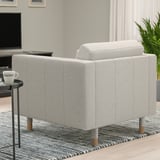 Grey LANDSKRONA armchair in living room, sleek and modern with wooden legs, on patterned rug beside small table with mug.