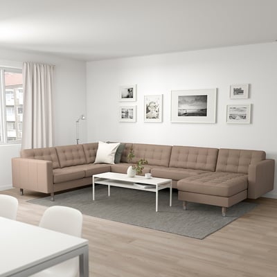 Modern living room with beige sofa, white coffee table, black-and-white photo gallery. Light wood floors and rug. Cozy ambiance.