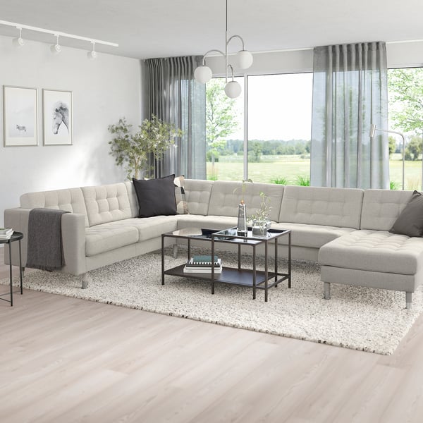 Modern living room with grey landssrona sectional sofa, black coffee table, large window, green curtains, and area rug.