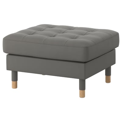 Grey fabric upholstered square ottoman with tufted top, wooden legs.