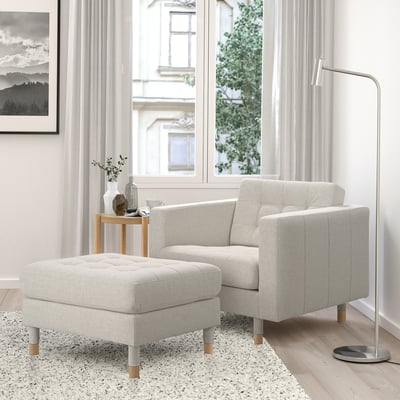 Minimalist living room with LANDSKRONA chair, lamp, rug, table, large windows, natural light, wall art.