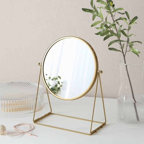 Gold-framed table mirror with a 3x magnifying side. Elegant home decor item.