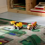 Two colorful toy vehicles, yellow and orange, sit on a city-themed play rug, promoting imaginative play.