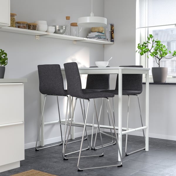 Modern grey LILLÅNÄS bar stools with cushioned seats & footrests line compact kitchen counter. Stainless steel legs, minimalist design.