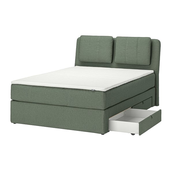 Modern green bed with sloped head, cushions, and under-bed storage. Upholstered fabric, oak legs.