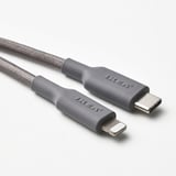 Gray ikea charging cable with usb-c & lightning connectors, woven texture, laid on white background.