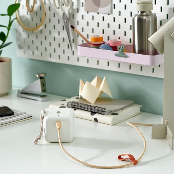 Desk with LILLHULT usb cable coiled neatly, books, origami, and storage boxes on pegboard.
