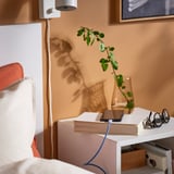 Cozy room with bed, white nightstand, and vibrant 3m LILLHULT charging cable.
