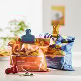 Bag clips seal snack bags; fridge magnets hold items. Three bags shown with colored clips.