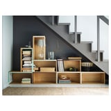 Wooden staircase shelves with books, lamp, and decor. Neutral jute rug adds warmth.