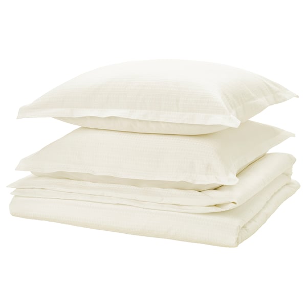 Folded white bed linen set with waffle texture, neatly stacked, light and soft.