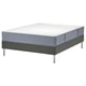 Displays a bed with a gray LYNGÖR base and white topper. It has a modern design with metal legs and a rectangular shape.