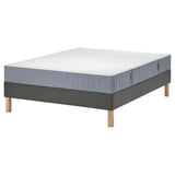 A gray LYNGÖR bed base with a white valevåg mattress. It has wooden legs and a reinforced edge for safety.