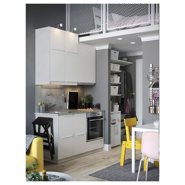 Modern kitchen with white cabinets, yellow chairs, and a small dining area.
