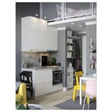 Modern kitchen with white cabinets, yellow chairs, and a small dining area.