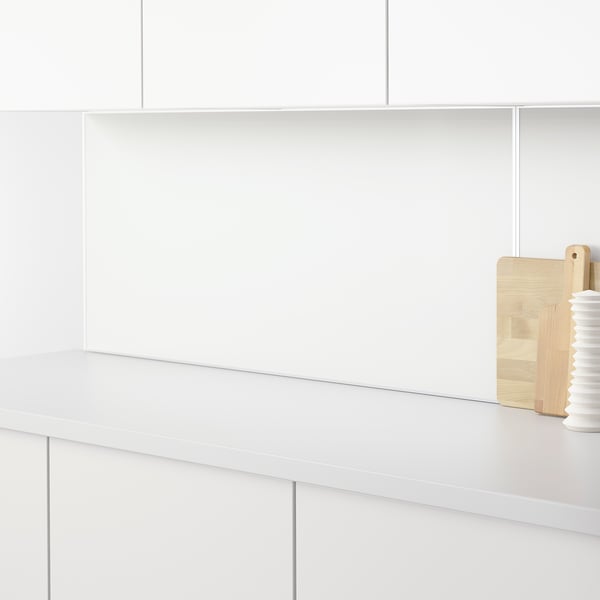 White countertop with wooden cutting boards and a white jar. The counter is sleek and clean, ideal for kitchen prep.