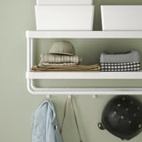 Shelf with hooks stores hat, towels, and bags. Organizes entryway with easy access.