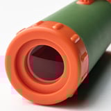 Close-up of green and orange telescope, focusing on lens. Durable build, textured grip.