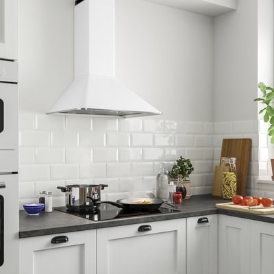 Modern kitchen with MATTRADITION hood, smooth edges, rocker switches. Silver filter, white cabinets, black countertops, various items.