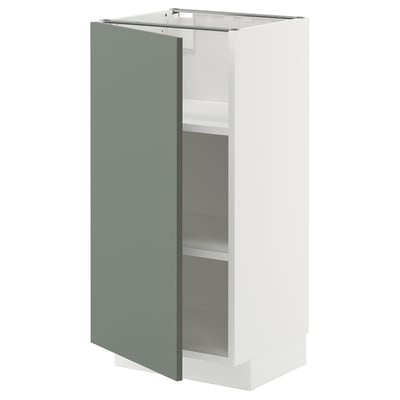 A white METOD kitchen cabinet with a grey-green door and two shelves. It has a modern, square shape and a 25-year guarantee.