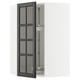 Open METOD kitchen cabinet with black glass doors featuring beveled edges.