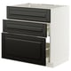 Modern white kitchen cabinet with three black beveled drawers.