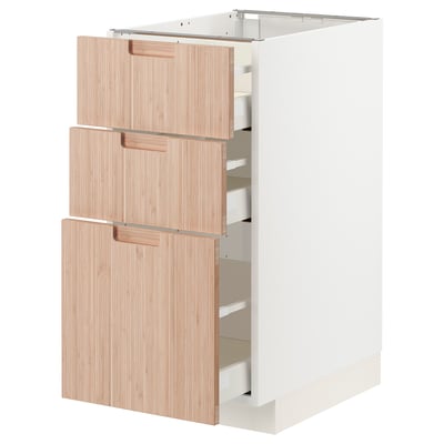 A modern white kitchen cabinet with three light wooden drawers. The drawers have sleek, light handles and provide organized storage.
