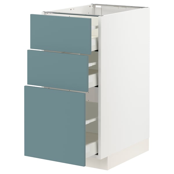 A modern white METOD kitchen cabinet with three turquoise drawers. The cabinet is rectangular with sleek, smooth surfaces and self-closing drawers.