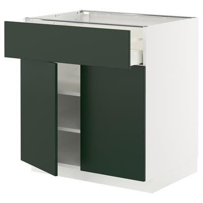 A METOD kitchen cabinet with dark green havstorp fronts, a white base, and adjustable shelves.