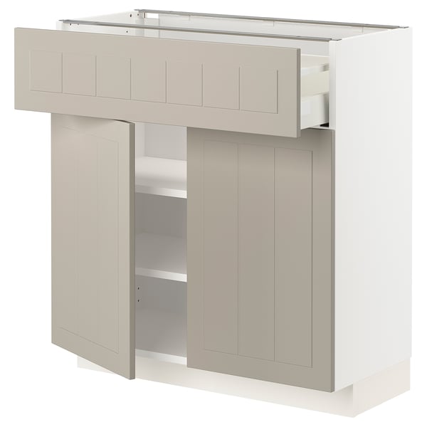 A beige METOD kitchen cabinet with a crafted look, featuring drawers and adjustable shelves.