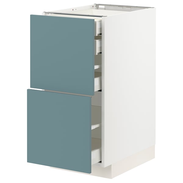 A white METOD kitchen cabinet with three turquoise drawers, featuring a sleek modern design.