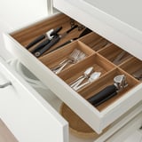 Organized cutlery drawer with compartments in modern kitchen.