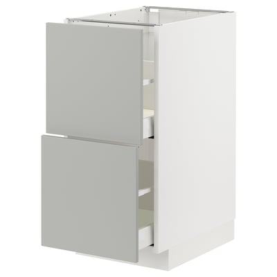 Modern white kitchen cabinet with light grey drawers and doors.
