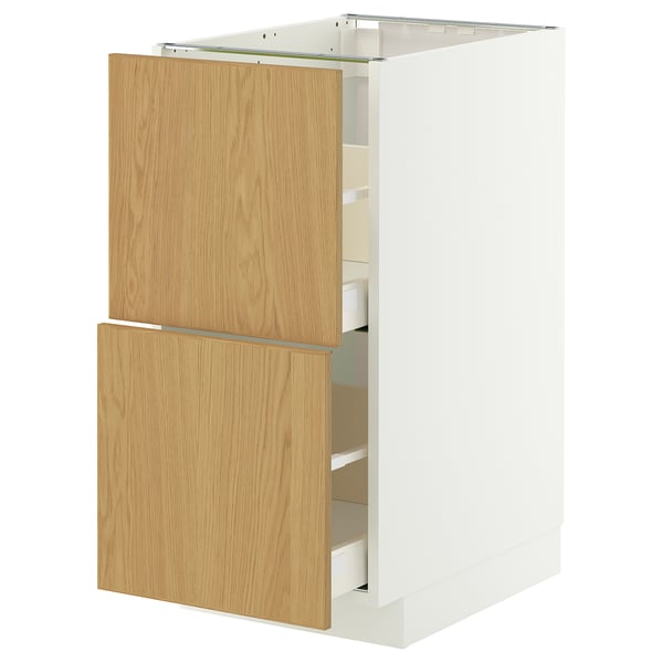 A white METOD kitchen cabinet with light oak drawers.