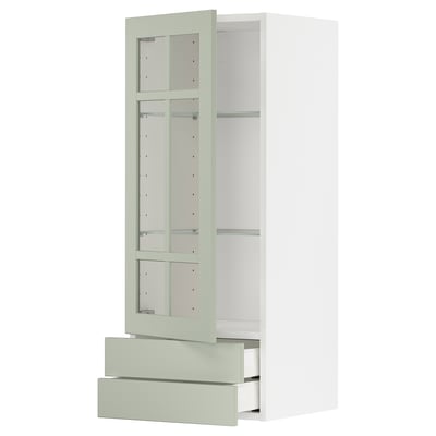 Modern kitchen cabinet: METOD with green stensund glass doors, white frames, adjustable shelf, soft-close drawers. Sleek, vertical design.
